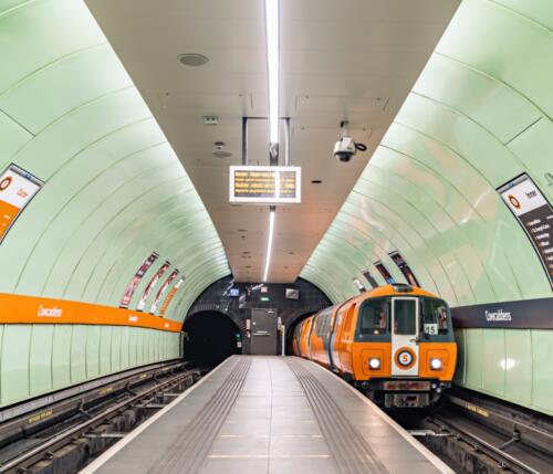 A tunnel with a train on the right tracks inside Glasgow Subway